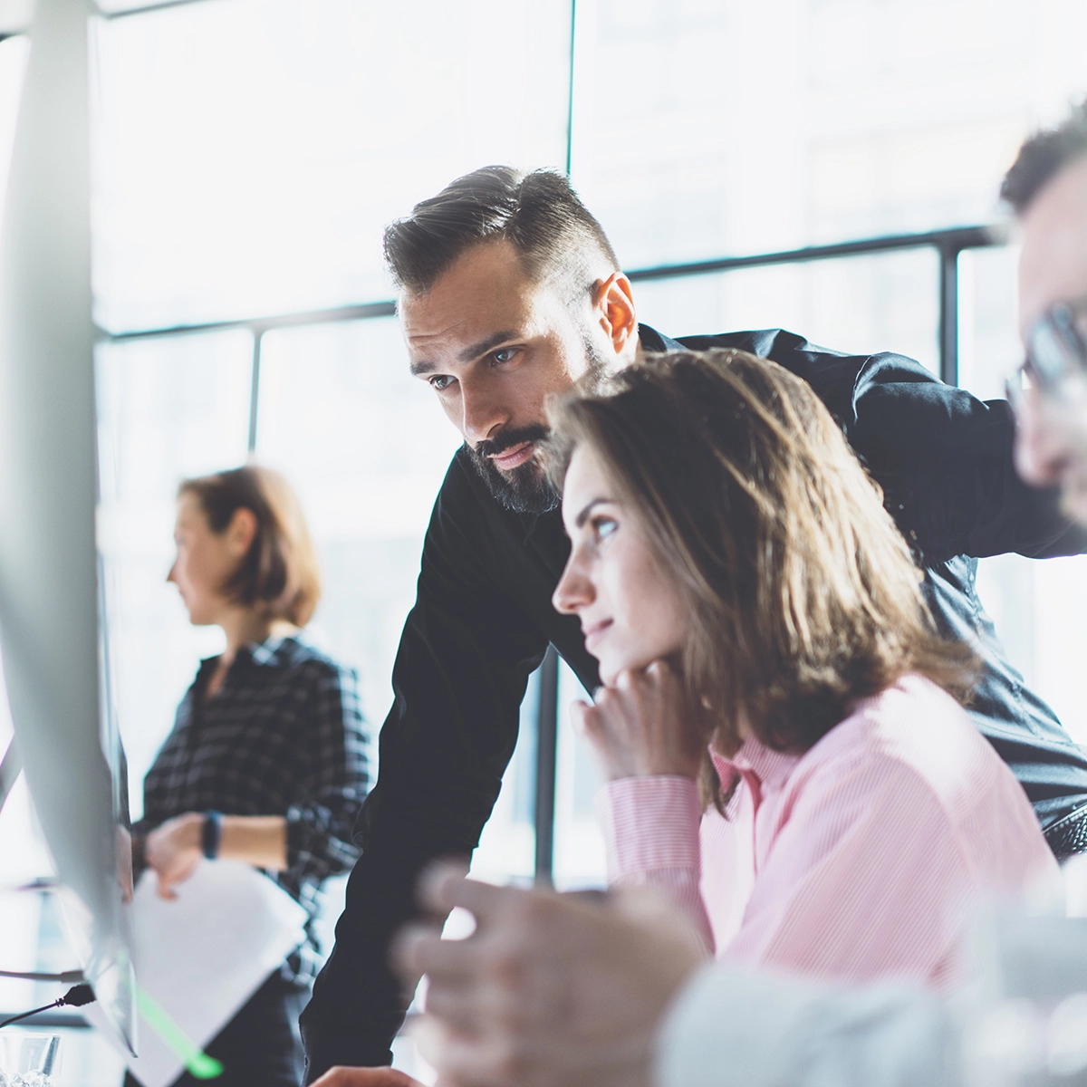 Man helping a woman at the computer